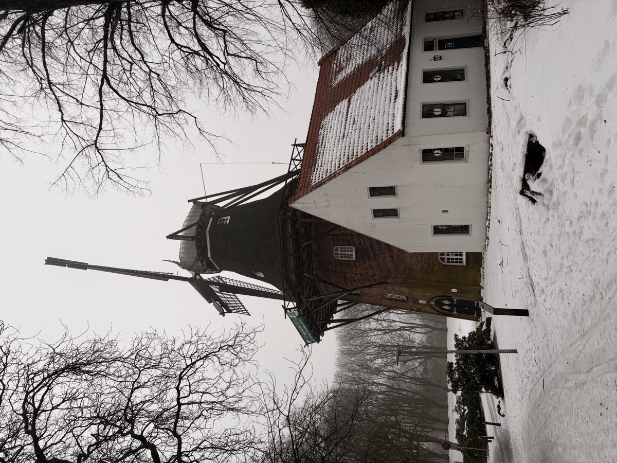 Mühle und weißes Müllerhaus an einem verschneiten Wintertag