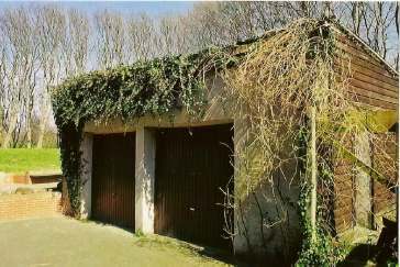 Das alte Stallgebäude als efeuüberwucherte Doppelgarage vor der Restaurierung