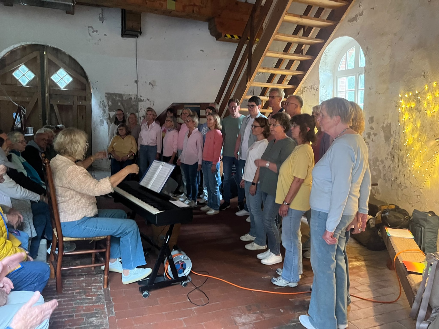 Der Chorwurm singt im Erdgeschoss der Vrouw Johanna, begleitet am Klavier